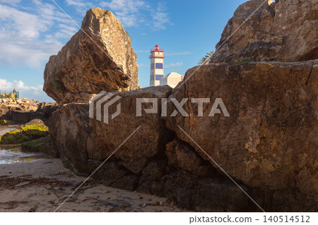 Santa Marta Lighthouse Behind Coastal Rocks in Cascais Portugal Santa Marta Lighthouse Behind Coastal Rocks in Cascais Portugal 140514512