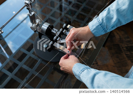 Man adjusting professional knife sharpener manual tool. Expert setting up precision blade sharpening device for maintenance. Metallic machine equipment for hobbyist and cooking master. Man adjusting professional knife sharpener manual tool. Expert setting up precision blade sharpening device for maintenance. Metallic machine equipment for hobbyist and cooking master. 140514566