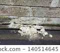 A block wall made of Oya stone that has deteriorated over time, crumbling and falling apart. 140514645