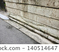A stone wall made of Oya stone that has deteriorated due to weathering, resulting in surface defects, wear, and peeling. 140514647