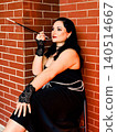 Elegant woman embodying 1920s flapper style holding cigarette holder 140514667