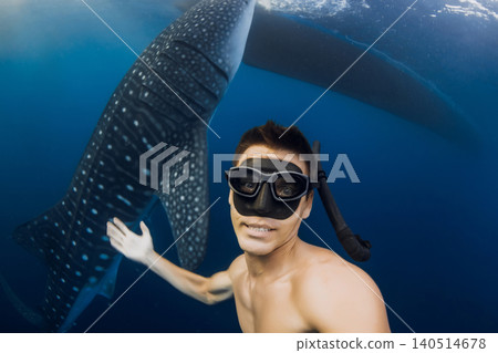 Smiling man freediver with whale shark in crystal blue water, tropical ocean travel experience Smiling man freediver with whale shark in crystal blue water, tropical ocean travel experience 140514678