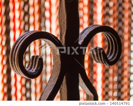 Ornate wrought iron scroll detail contrasting soft background 140514791