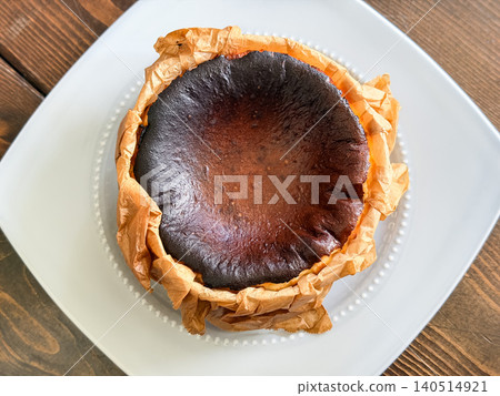 A Western-style cheesecake. Directly above the cheesecake, still wrapped in the baking sheet it came out of the oven. A Western-style cheesecake. Directly above the cheesecake, still wrapped in the baking sheet it came out of the oven. 140514921