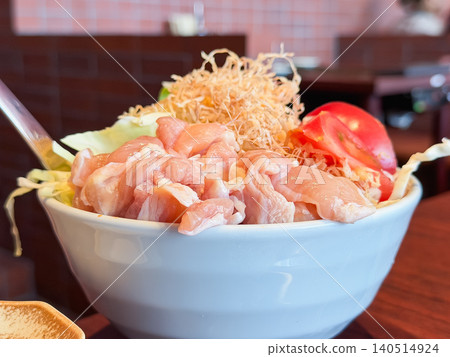 特寫鏡頭展示了一個碗，碗裡盛放著製作文字燒的食材，例如雞肉、高麗菜和番茄。 140514924