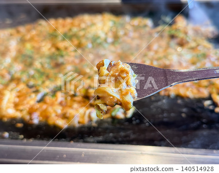 Monjayaki being cooked on a griddle. Curry monjayaki made with curry-flavored cabbage and chicken. Close-up. Monjayaki being cooked on a griddle. Curry monjayaki made with curry-flavored cabbage and chicken. Close-up. 140514928