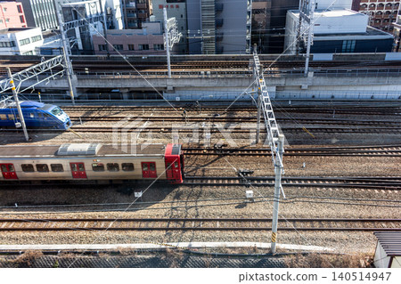 An aerial view of multiple trains running through an urban area and the intricately intersecting railway lines. An aerial view of multiple trains running through an urban area and the intricately intersecting railway lines. 140514947