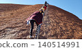 [Before climbing was prohibited] Scenes of climbing Ayers Rock, Australia, on its steep slopes, relying on chains to ascend. 140514991