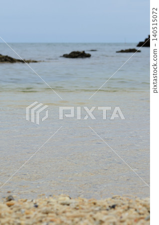 A vertical background of waves and coral sand on a cloudy Okinawan coast. A vertical background of waves and coral sand on a cloudy Okinawan coast. 140515072
