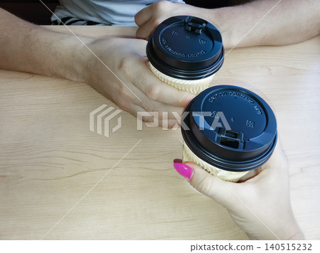 Couples coffee break with two paper cups in hands, morning date concept. Couples coffee break with two paper cups in hands, morning date concept. 140515232