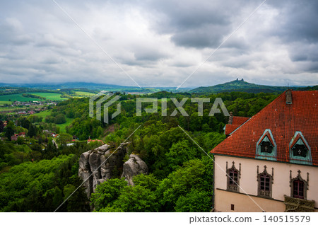 View from the tower of Hruba Skala Castle over the landscape of Bohemian Paradise (Cesky raj), Czech Republic, with silhouette of Trosky Castle ruin in the distance under dramatic soft sky panorama 140515579