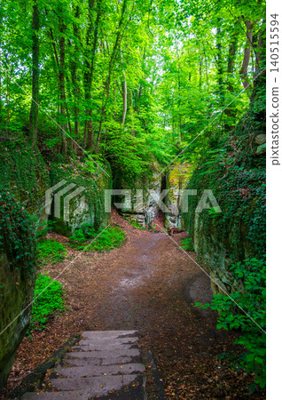 Massive sandstone rock formations along a forest trail in Bohemian Paradise (Cesky raj), Hruba Skala area (Hruboskalsko), Czech Republic, with giant stones rising above woodland path Massive sandstone rock formations along a forest trail in Bohemian Paradise (Cesky raj), Hruba Skala area (Hruboskalsko), Czech Republic, with giant stones rising above woodland path 140515594