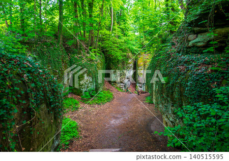 Massive sandstone rock formations along a forest trail in Bohemian Paradise (Cesky raj), Hruba Skala area (Hruboskalsko), Czech Republic, with giant stones rising above woodland path Massive sandstone rock formations along a forest trail in Bohemian Paradise (Cesky raj), Hruba Skala area (Hruboskalsko), Czech Republic, with giant stones rising above woodland path 140515595