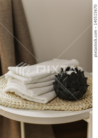 Minimalist still life of luxury spa essentials. White cotton towels with decorative candle on a table. Minimalist still life of luxury spa essentials. White cotton towels with decorative candle on a table. 140515670