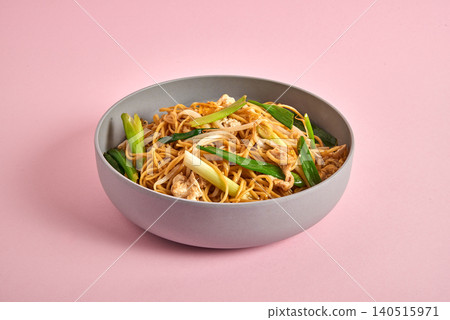 Tasty asian noodles with vegetables on pink background Tasty asian noodles with vegetables on pink background 140515971