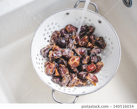 Dried brown dates in a colander Dried brown dates in a colander 140516034