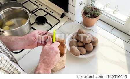 Man peels a potato 140516045