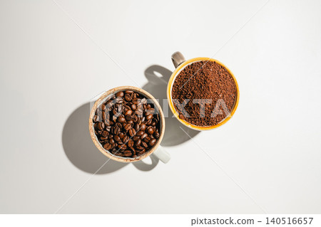 Roasted coffee beans and ground coffee in cups on white background, flat lay with copy space Roasted coffee beans and ground coffee in cups on white background, flat lay with copy space 140516657