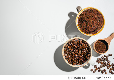 Roasted coffee beans and ground coffee in cups on white background, flat lay with copy space Roasted coffee beans and ground coffee in cups on white background, flat lay with copy space 140516662
