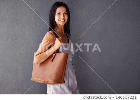 Studio, portrait and handbag with fashion, joy and accessories with dress and smile. Woman, face and model with confidence, beauty and happiness with purse and style isolated on gray wall background 140517221