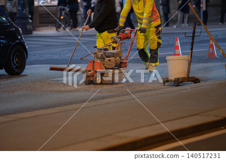 Workers repainting lane markings in city street Workers repainting lane markings in city street 140517231