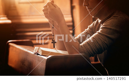 Christian woman praying in church. Hands crossed and Holy Bible on wooden desk. Christian woman praying in church. Hands crossed and Holy Bible on wooden desk. 140517291