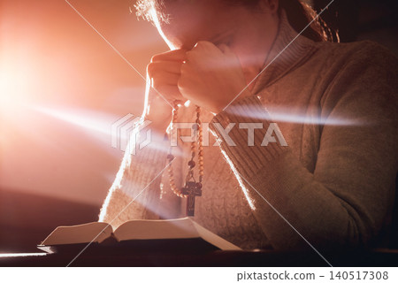Christian woman praying in church. Hands crossed and Holy Bible on wooden desk. Christian woman praying in church. Hands crossed and Holy Bible on wooden desk. 140517308