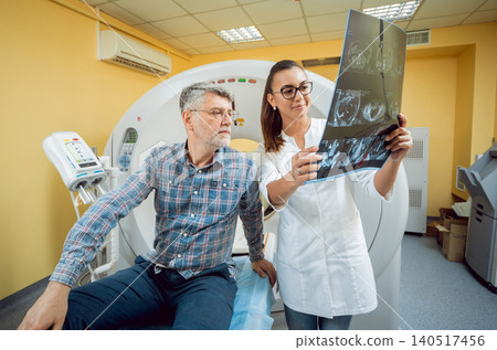 Radiologist with an male patient looking at x-ray. Radiologist with an male patient looking at x-ray. 140517456