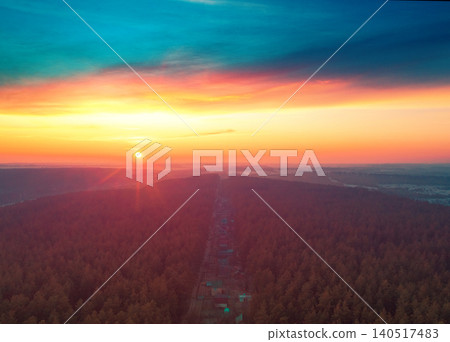 Beautiful dramatic evening sky over pine forest. Village in the forest during sunset. Aerial view Beautiful dramatic evening sky over pine forest. Village in the forest during sunset. Aerial view 140517483