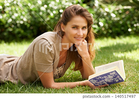Portrait, book and woman reading on grass, field and nature in garden, backyard and sunshine relax in summer. Female person, gen z girl and novel studying for learning, education and knowledge 140517497