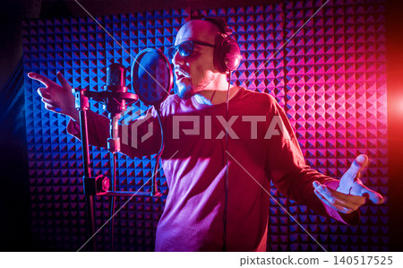 The singer sings with a microphone in the recording studio. The singer sings with a microphone in the recording studio. 140517525