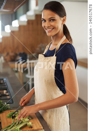 Woman, knife and vegetables for portrait in kitchen with smile, apron and cooking for nutrition for dinner. Girl, person and meal prep with vegan diet for health food, wellness and lunch in apartment Woman, knife and vegetables for portrait in kitchen with smile, apron and cooking for nutrition for dinner. Girl, person and meal prep with vegan diet for health food, wellness and lunch in apartment 140517678