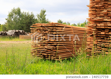 Stacks of sawn timber boards at open air lumberyard, packed wooden planks pile for construction material supply Stacks of sawn timber boards at open air lumberyard, packed wooden planks pile for construction material supply 140517739