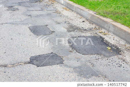 Asphalt road patching and pothole repair texture, grey street pavement surface with fresh dark bituminous layers close up Asphalt road patching and pothole repair texture, grey street pavement surface with fresh dark bituminous layers close up 140517742