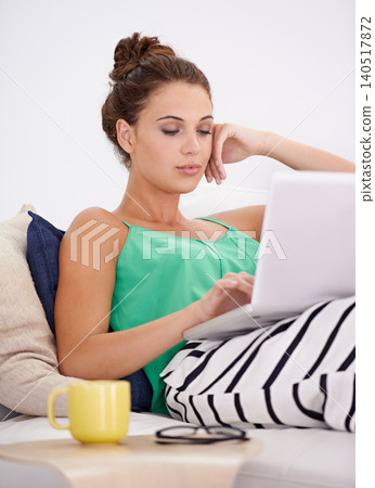 Student woman, laptop and working on couch busy, searching and concentration with computer in living room. Female person, casual outfit and coffee on sofa or lounge, online and connectivity in house Student woman, laptop and working on couch busy, searching and concentration with computer in living room. Female person, casual outfit and coffee on sofa or lounge, online and connectivity in house 140517872