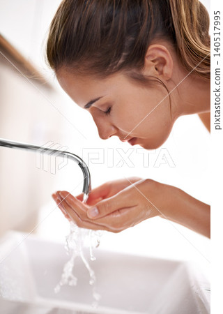 Woman, wellness and hygiene for washing face, skin and zinc in self care and beauty with smile in restroom. Female person, clean water and tap in bathroom, morning and happy for health at home Woman, wellness and hygiene for washing face, skin and zinc in self care and beauty with smile in restroom. Female person, clean water and tap in bathroom, morning and happy for health at home 140517995