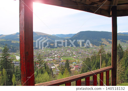 Panoramic view of a mountain village valley from a wooden lookout tower balcony Panoramic view of a mountain village valley from a wooden lookout tower balcony 140518132