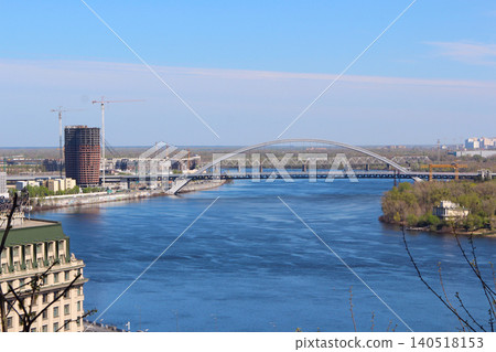 Podilskyi Bridge over the Dnieper River with city skyline and construction sites 140518153