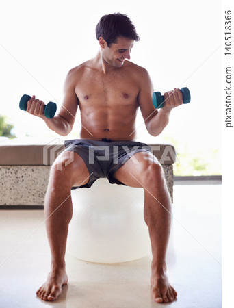 Man, exercise ball and dumbbells for weightlifting, fitness and muscle training for body and self care. Topless athlete, smile and endurance in workout at home for health, wellness and strength Man, exercise ball and dumbbells for weightlifting, fitness and muscle training for body and self care. Topless athlete, smile and endurance in workout at home for health, wellness and strength 140518366