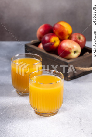 Fresh nectarine juice in glasses with ripe fruit Fresh nectarine juice in glasses with ripe fruit 140518382