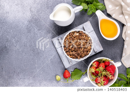 Chocolate granola breakfast ingredients with fresh strawberries and honey Chocolate granola breakfast ingredients with fresh strawberries and honey 140518403