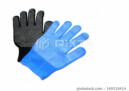 blue protective glove lying on top of a black glove on the right side of a white isolated background blue protective glove lying on top of a black glove on the right side of a white isolated background 140518414