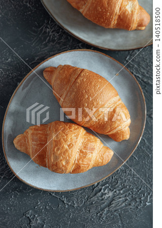 Flaky golden croissants on plates for breakfast Flaky golden croissants on plates for breakfast 140518500
