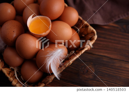 Brown eggs in basket with broken egg yolk Brown eggs in basket with broken egg yolk 140518503