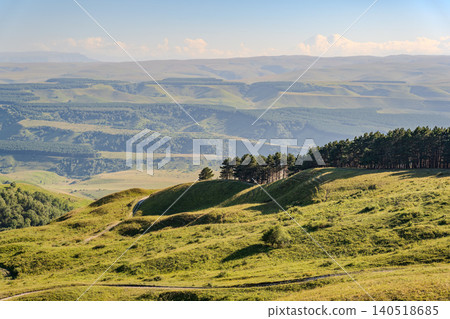 Layers of green mountains and hills in the haze during sunset. Panoramic View of Green hills and Meadow. Layers of green mountains and hills in the haze during sunset. Panoramic View of Green hills and Meadow. 140518685