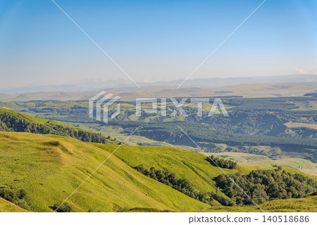 Layers of green mountains and hills in the haze during sunset. Panoramic View of Green hills and Meadow. Layers of green mountains and hills in the haze during sunset. Panoramic View of Green hills and Meadow. 140518686