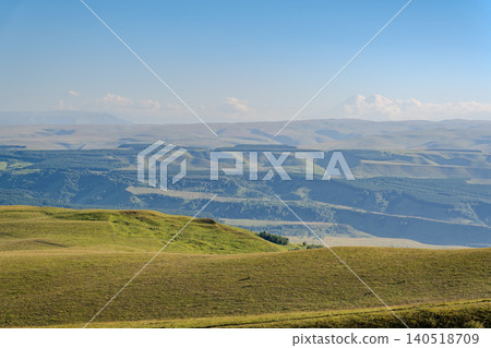Layers of green mountains and hills in the haze during sunset. Panoramic View of Green hills and Meadow. Layers of green mountains and hills in the haze during sunset. Panoramic View of Green hills and Meadow. 140518709
