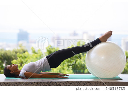 Woman, yoga and stretching with exercise ball for fitness, workout or outdoor training at home. Young female person or calm yogi in relax or pilates for zen, body warm up or wellness on mat at house Woman, yoga and stretching with exercise ball for fitness, workout or outdoor training at home. Young female person or calm yogi in relax or pilates for zen, body warm up or wellness on mat at house 140518785