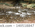 Mountain stream flowing over stones and rocky riverbed 140518847