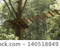 Wooden suspension bridge and platform in high ropes adventure park forest 140518849